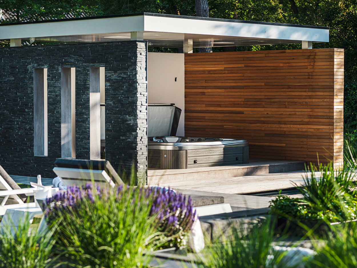 Modernes Gartenpavillon mit integriertem Whirlpool und stilvoller Kombination aus Naturstein- und Holzelementen.